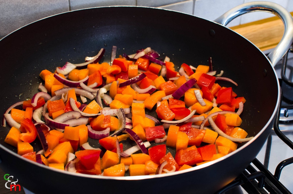Scaldate la cipolla, il peperone e le carote a fuoco alto in un po&#039; d&#039;olio caldo.
