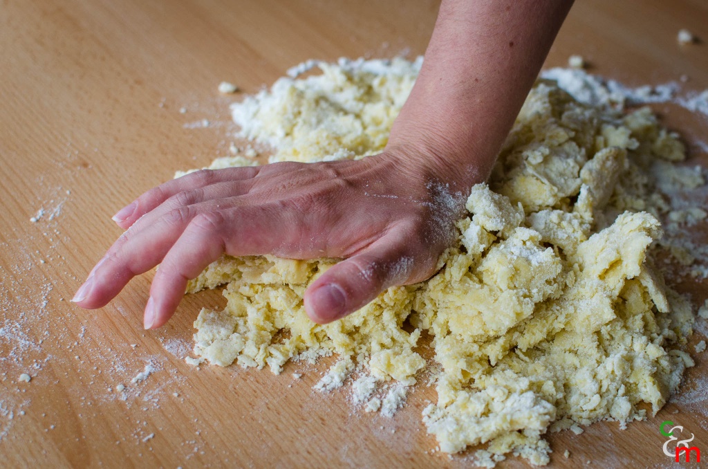Impastate con il palmo della mano gli ingredienti della pasta frolla, aiutandovi con una spatola