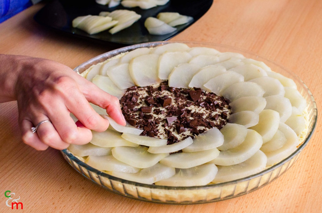 Puneti blatul la cuptor pentru 15 minute, dupa care adaugati ciocolata si ornati tarta cu feliutele de pere.