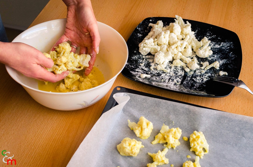 Mettete il cavolfiore infarinato nel composto di uovo e latte, e mescolate bene con le mani per ricoprirlo uniformemente.